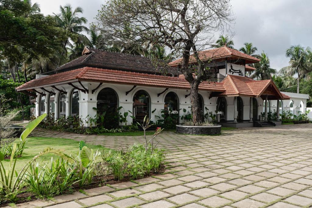 IrimbranallūrMayanadhi Resort的房屋设有瓷砖屋顶和庭院