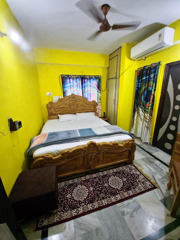 a bedroom with a bed with yellow walls and a ceiling at mahitra beautiful homestay in Patna