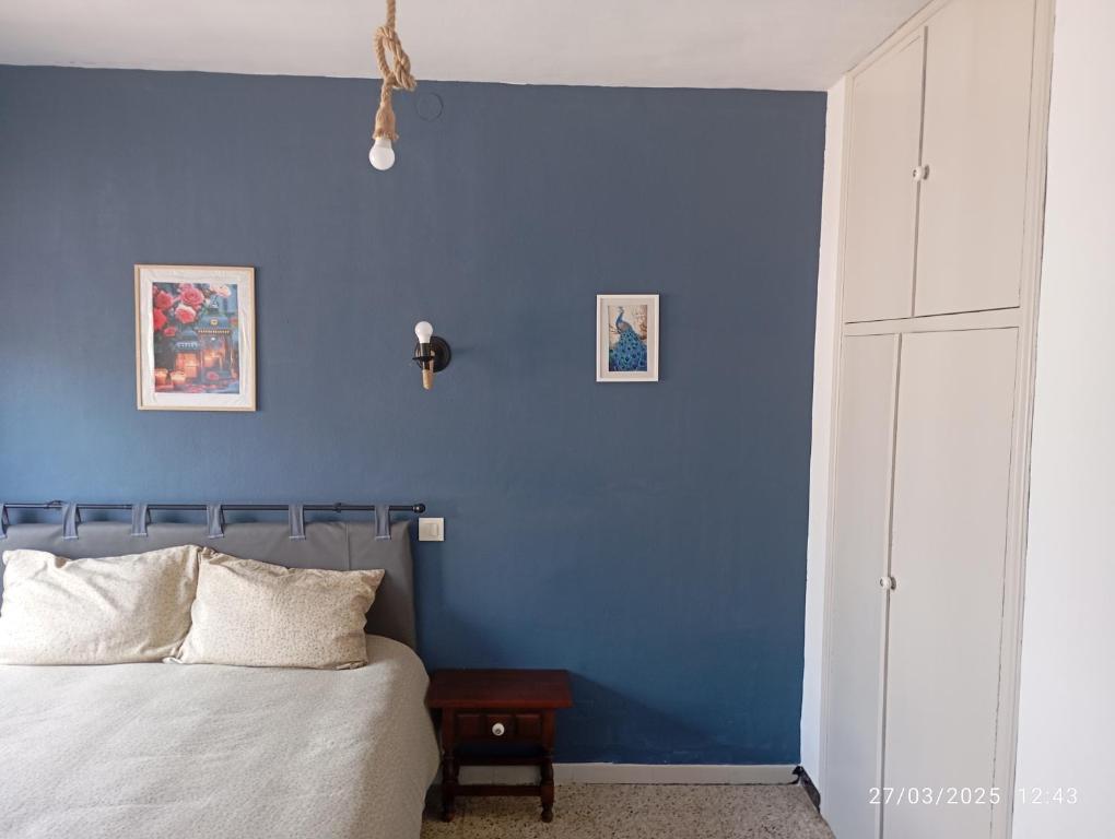 a blue bedroom with a bed and a blue wall at Hostal prados abiertos in La Parra