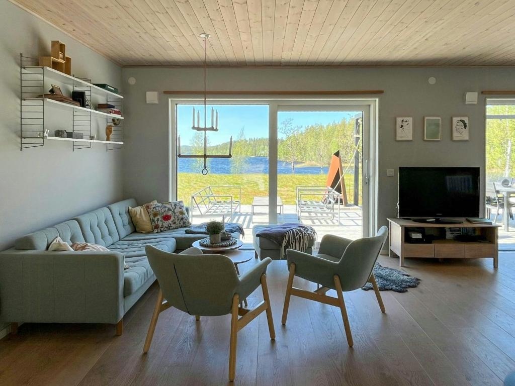 埃克舍Lake Cottage With Sunsets Over Försjön的带沙发、桌子和椅子的客厅