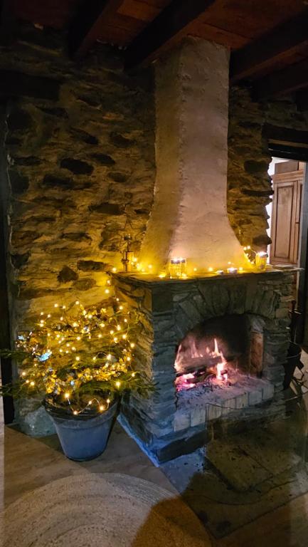 a stone fireplace with christmas lights in a room at Chalet coeur d'alpage La Plagne Les Arcs in La Plagne Tarentaise