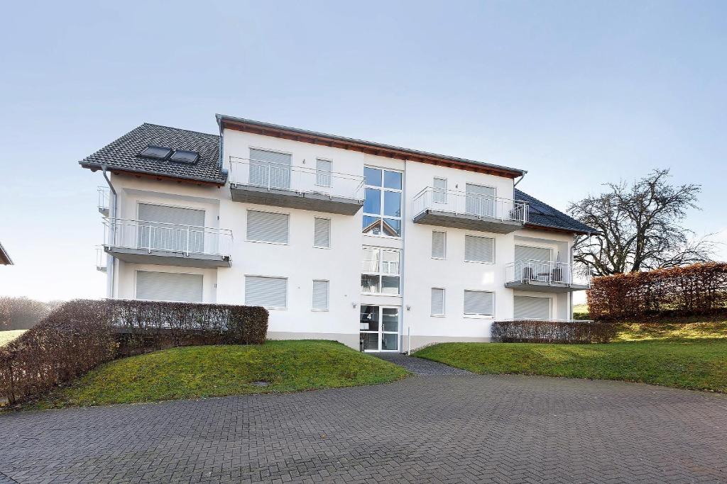 un grande edificio bianco con un sentiero di fronte di Markgraf Apartments Haus 2 a Hertingen