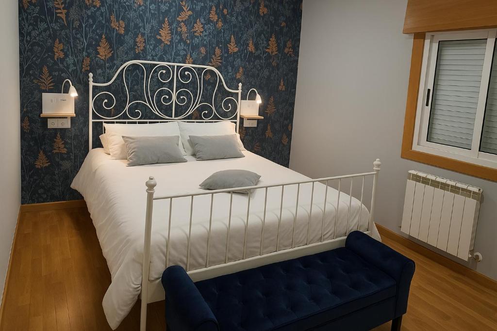 1 dormitorio con cama y banco azul en CHALET A SOLO 5 MIN DE OURENSE CIUDAD con jardín y barbacoa, en Ourense