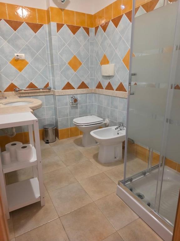 Un baño con inodoro, lavabo y ducha. en Is Molas Domus Michela, en Is Molas 