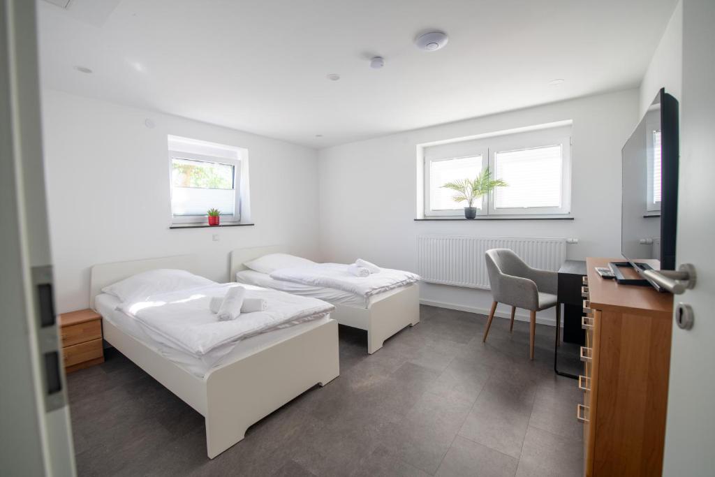 ein Krankenhauszimmer mit 2 Betten und einem Tisch in der Unterkunft W&P Living Wohnung mit Ausblick - Parkplatz in Biberbach