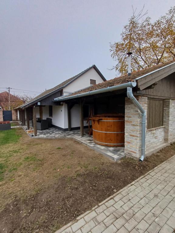 a house with a large tub on the side of it at Borka-land Vendégház in Deszk