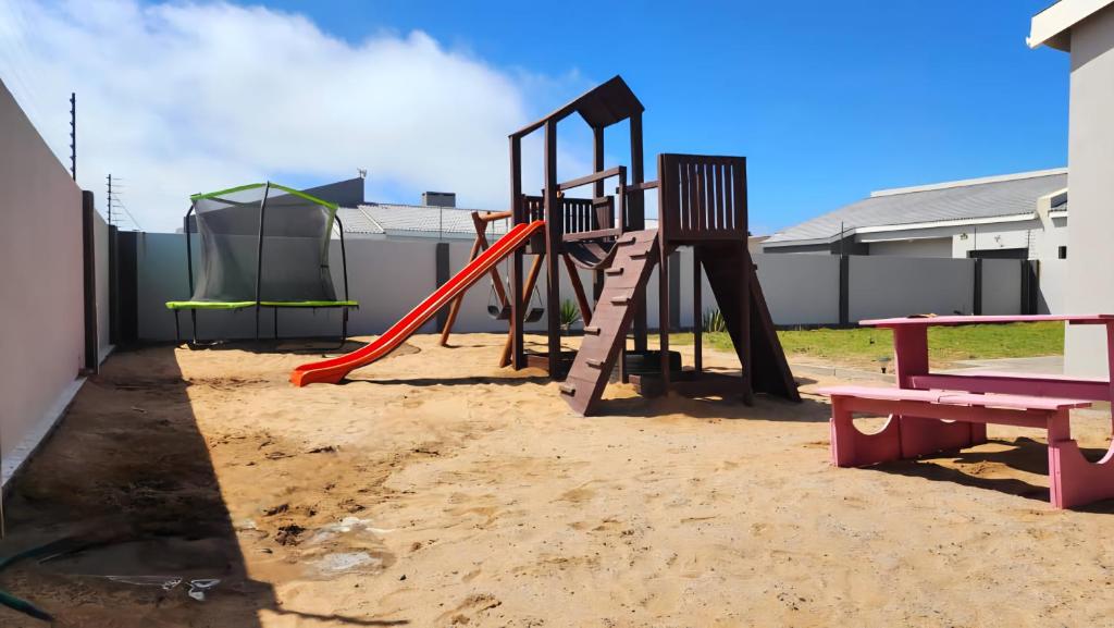 a playground with a slide in the sand at Nikita's Holiday Home - Walvis Bay in Walvis Bay