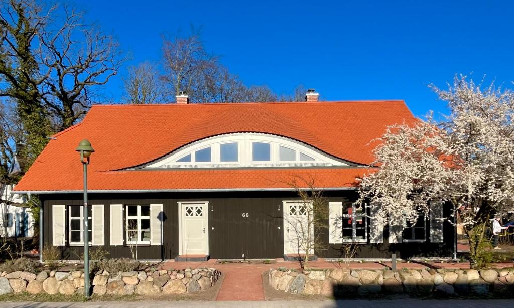 ein Haus mit orangefarbenem Dach in der Unterkunft Ostseedomizil "Ankerbuk", Ferienhaus Austernfischer in Born