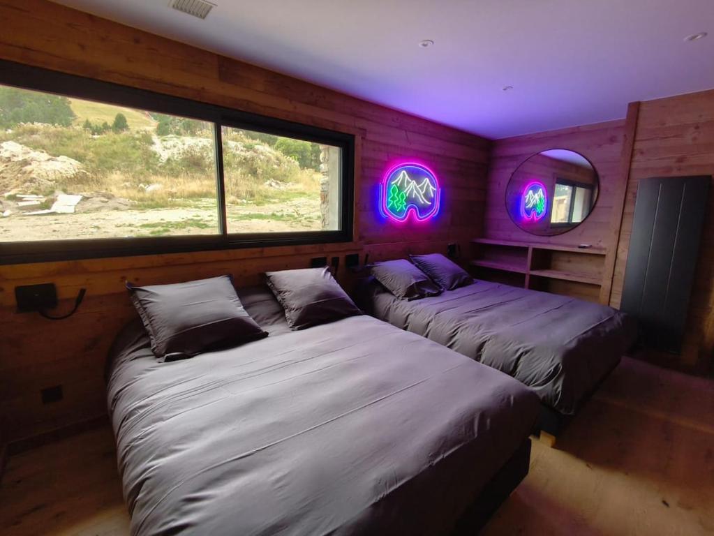two beds in a room with purple lights at Chalet Prestige - Ski au pieds - Les Angles in Les Angles