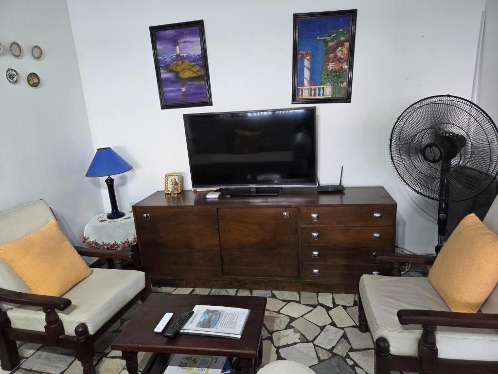 a living room with a flat screen tv on a dresser at Casa Al pie del Cerro in Yerba Buena