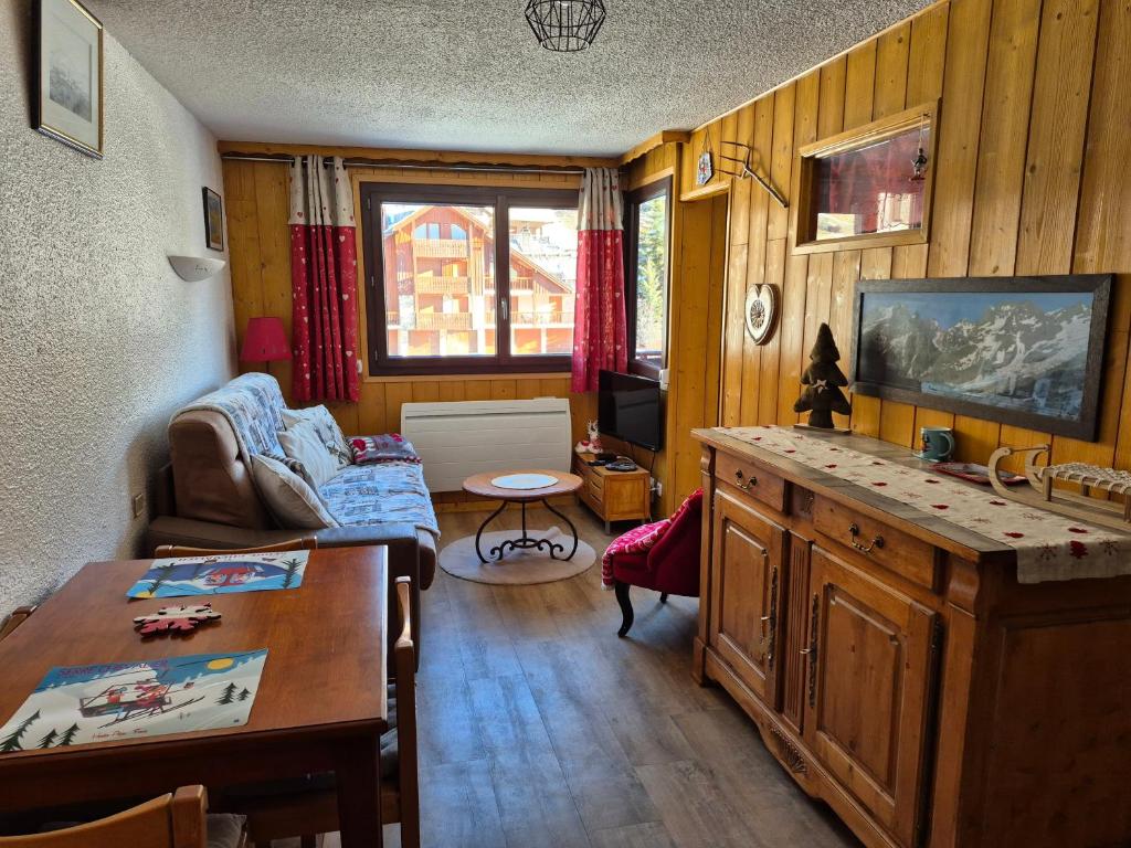 ein Wohnzimmer mit Sofa und Tisch in der Unterkunft Les Mélèzes in Saint-Chaffrey