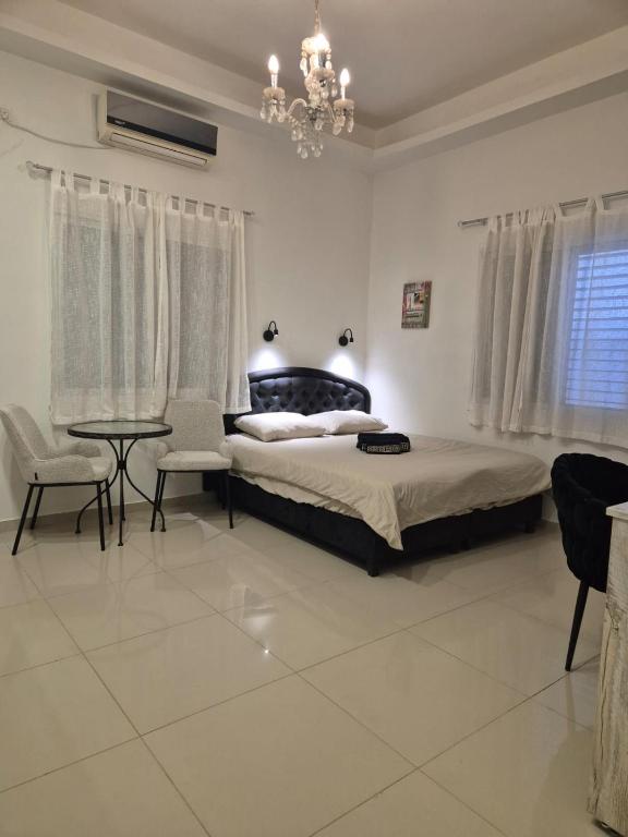 a bedroom with a bed and a table and chairs at pinsker apartment city center in Petaẖ Tiqwa