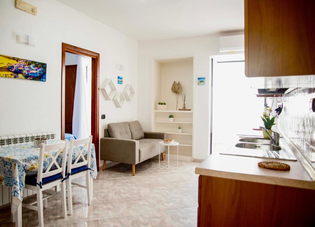 a kitchen and living room with a table and a couch at Casa Francesco Seaside in Sant'Angelo D'Ischia