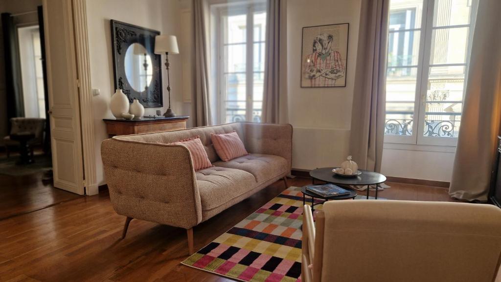 un soggiorno con un divano e un tavolo di Escale citadine au centre d'Avignon, climatisation, appartement de charme, spacieux et lumineux ad Avignone