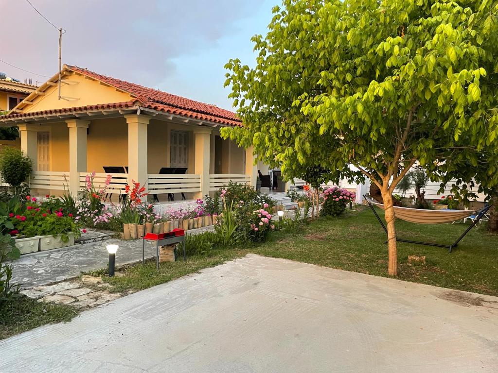 een huis met een hangmat voor een tuin bij Dada's Cottage in Argyrádes