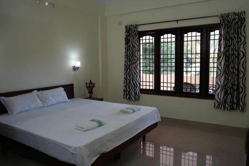 En eller flere senge i et værelse på Dew Drops Inn kovalam