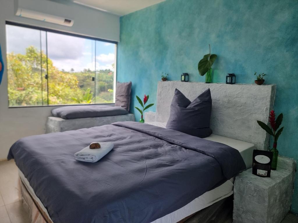 een slaapkamer met een groot bed en een raam bij Fazenda de Jehne in Camamu