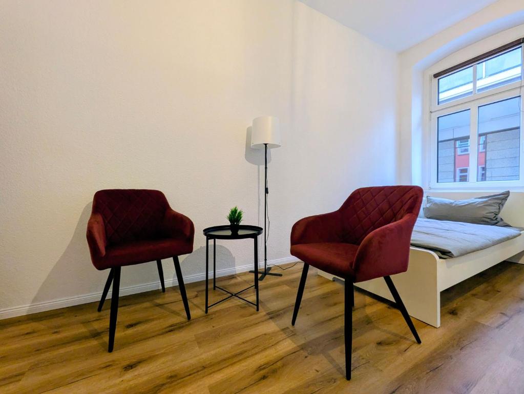 1 Schlafzimmer mit 2 Stühlen und 1 Bett mit einem Fenster in der Unterkunft AltstadtQuartier Bautzen in Bautzen