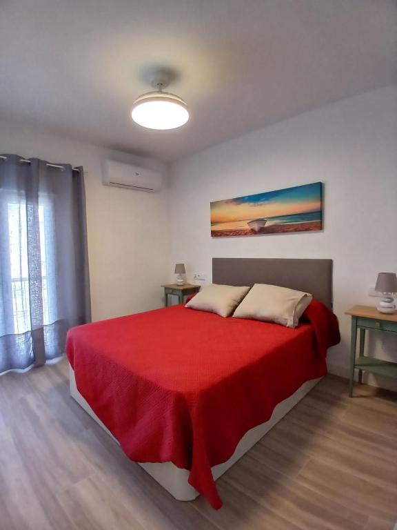 ein Schlafzimmer mit einem roten Bett mit einer roten Decke in der Unterkunft Casa Remo - Motril in Motril