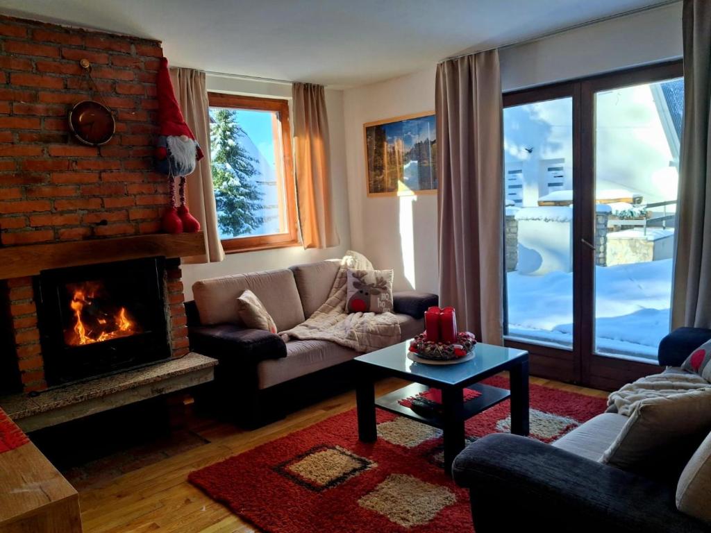 una sala de estar con un sofá y una chimenea en Apartments K.I.D.S., en Vlašić
