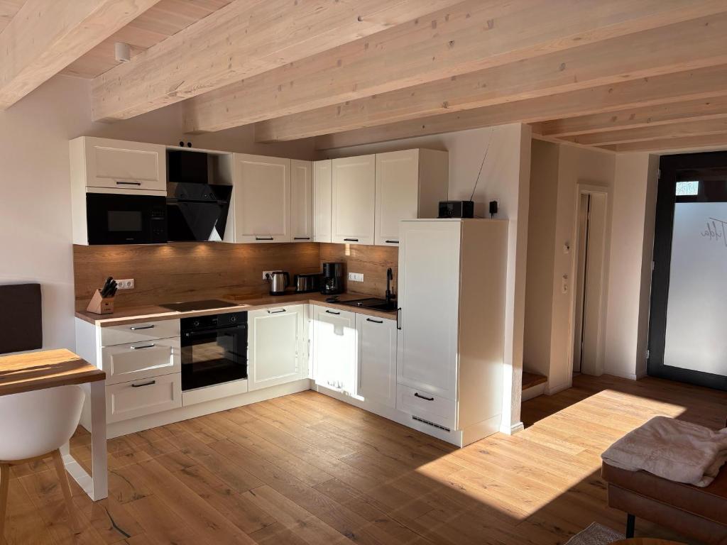 HohenkirchenGulfhof Wangermeer 2 Tilda的厨房配有白色橱柜和木地板