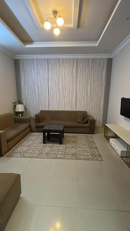 a living room with a couch and a table at شقة غرفتين وصالة 5 in Al Baha