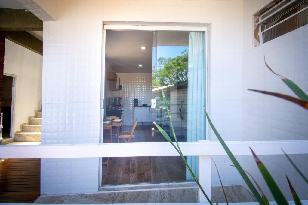 une maison avec une porte vitrée menant à une cuisine dans l'établissement Pousada Vila Merced, à Búzios