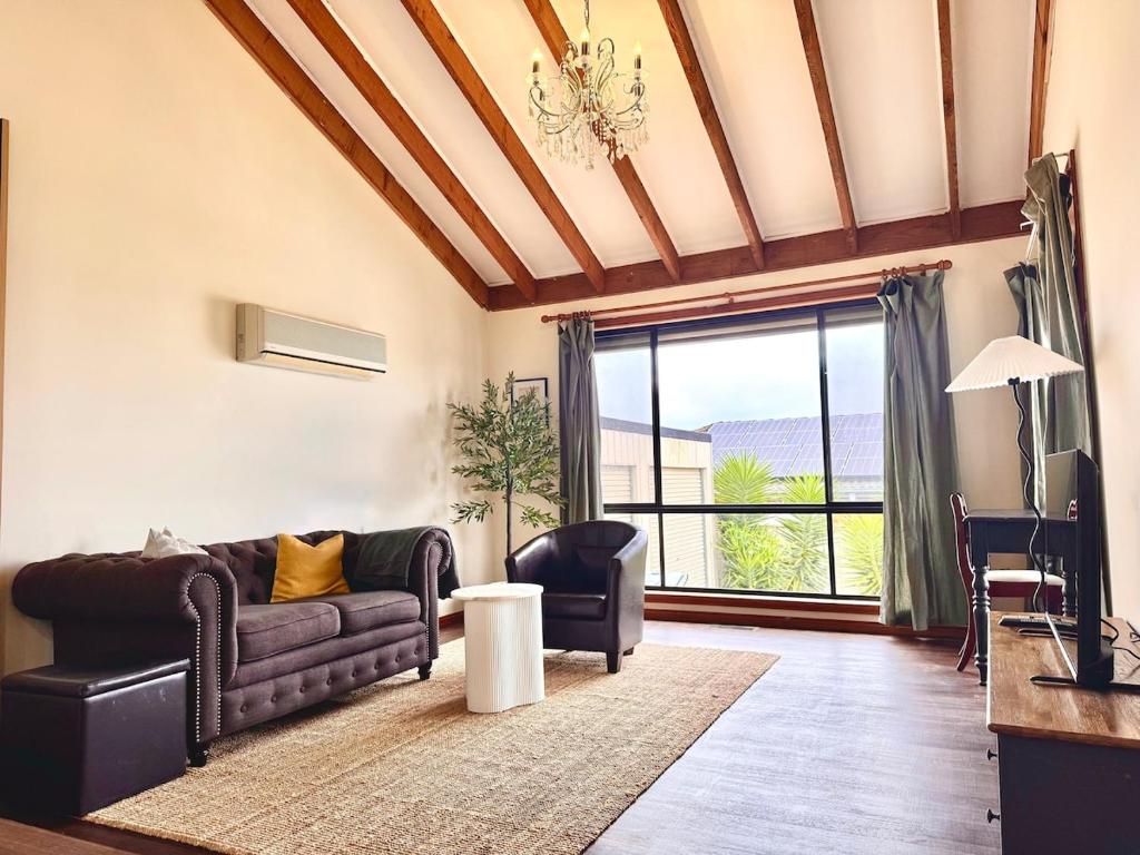 a living room with a couch and a large window at Comfortable 2BR Home in Hallam in Hallam