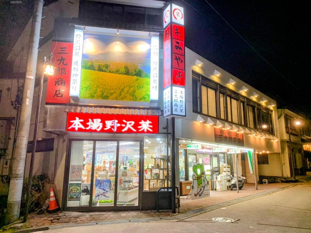 ein Geschäft mit Schildern an der Seite eines Gebäudes in der Unterkunft Rou in Nozawa Onsen