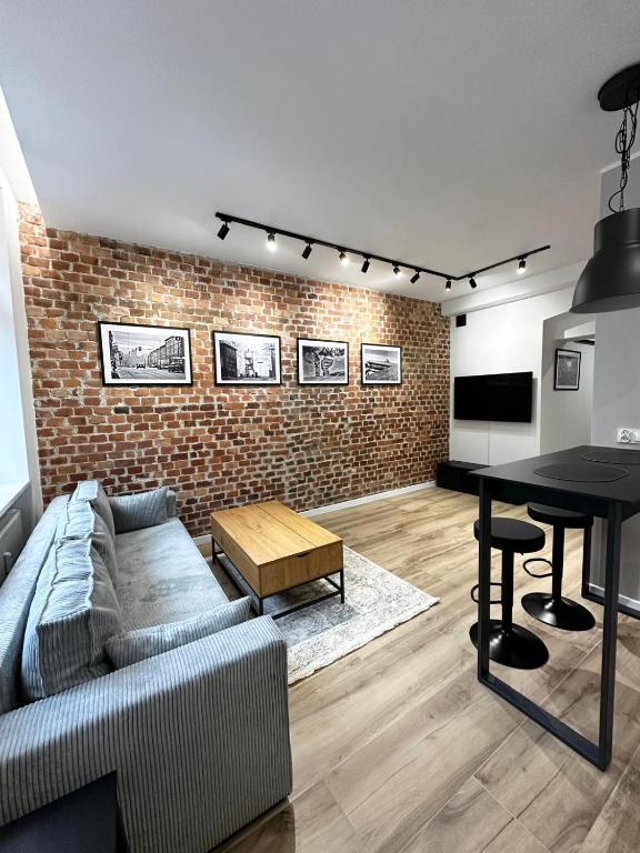 a living room with a couch and a table at SILESIAN LOFT Apartment in Ruda Śląska