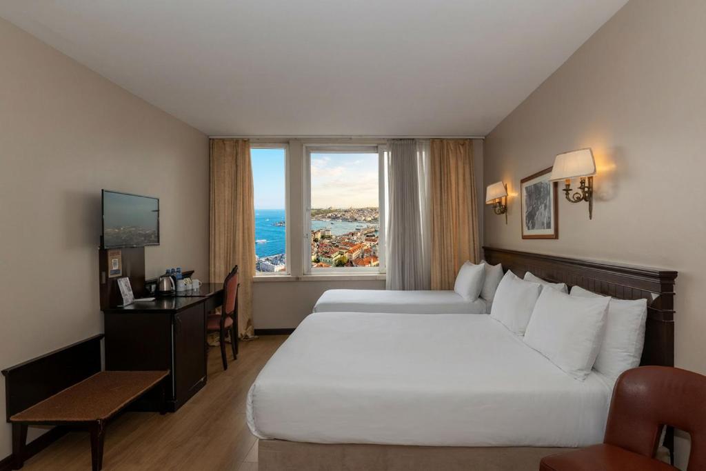 a hotel room with two beds and a window at Pera Rose Hotel & SPA in Istanbul