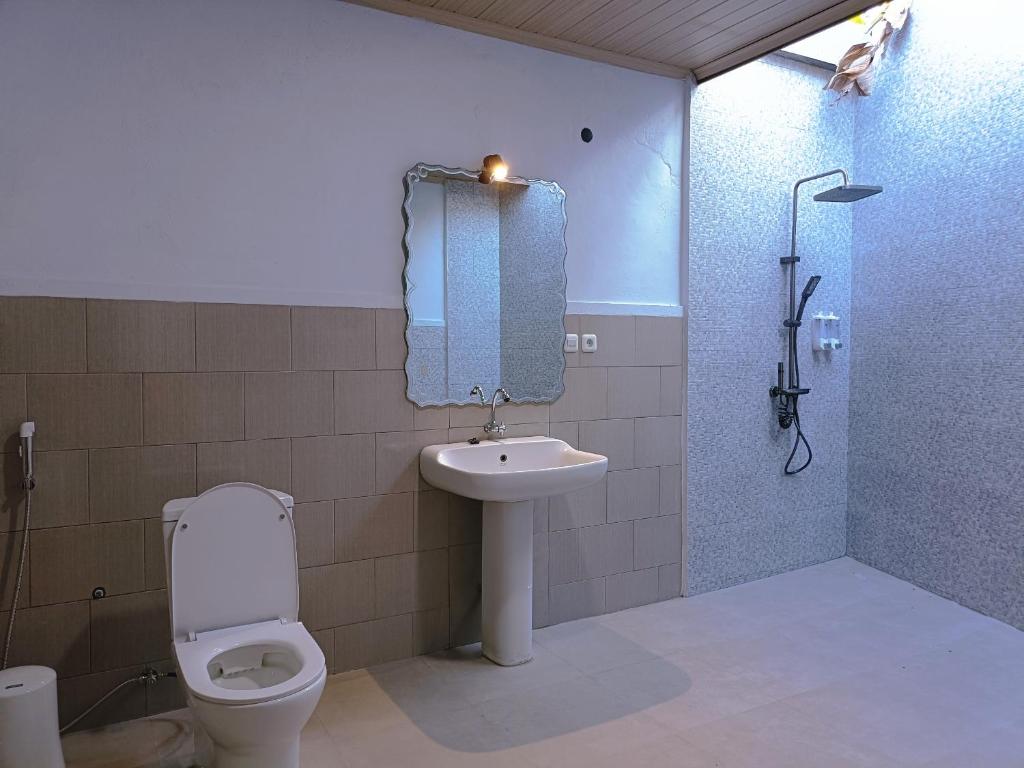 a bathroom with a toilet and a sink and a shower at Rini hotel in Lovina