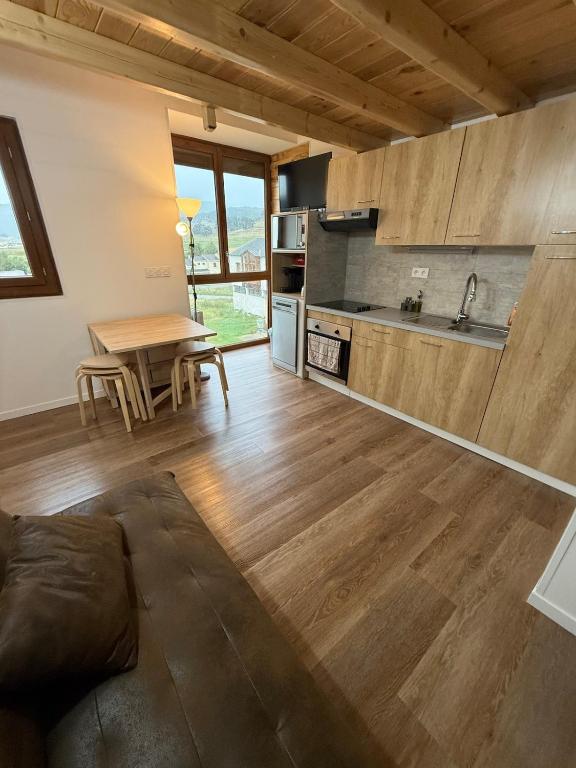 a kitchen and living room with a wooden floor at Cozy Lac - Puyvalador in Puyvalador