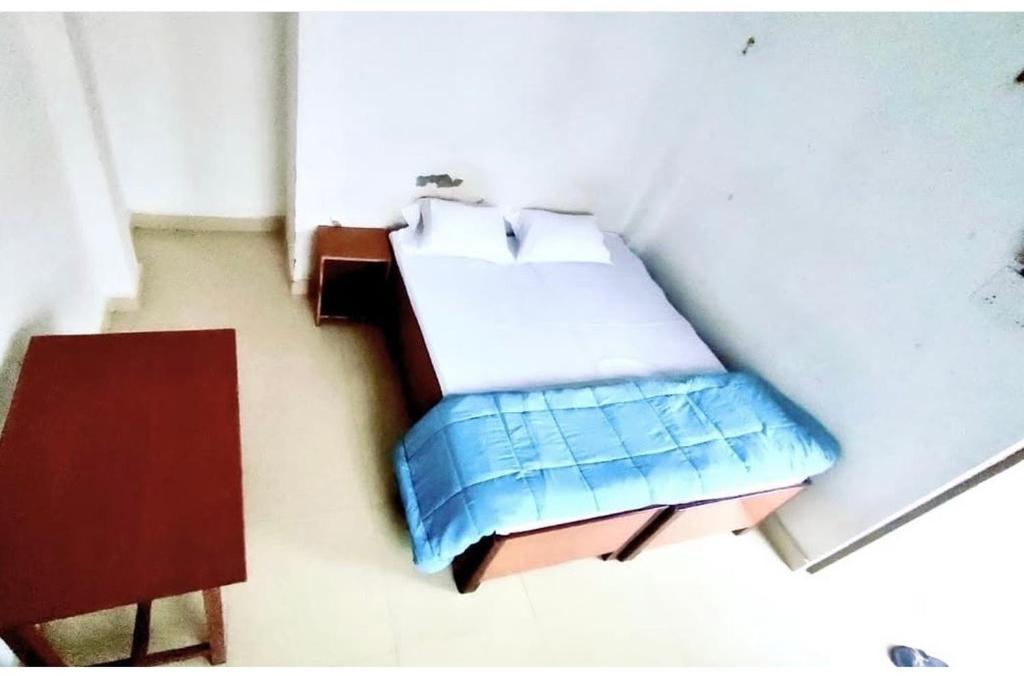 ein kleines Zimmer mit einem Bett und einem Tisch in der Unterkunft Veda hotel and home stay in Prayagraj