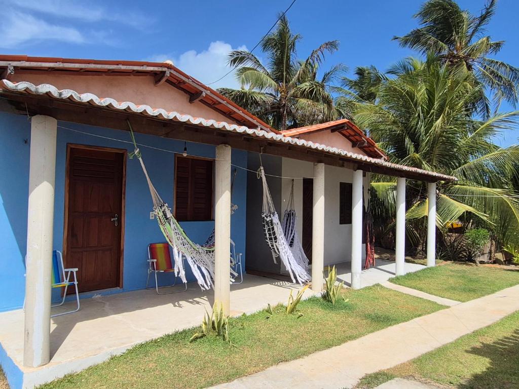 een blauw huis met hangmatten ervoor bij Chalés Brisa do Mar in Amontada