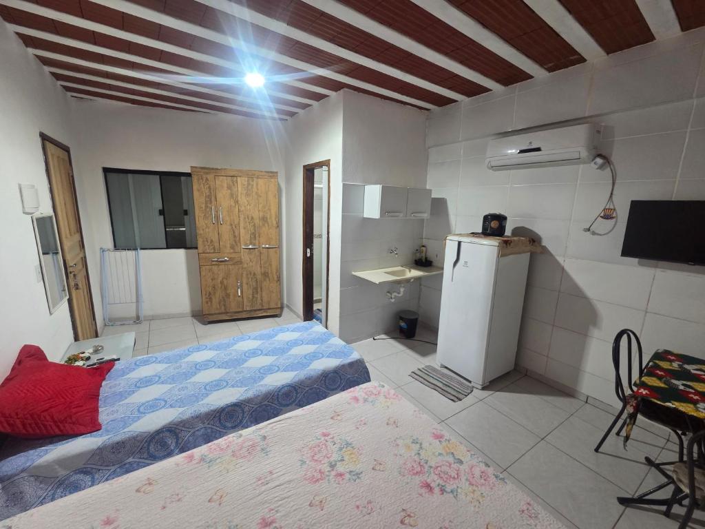 Una pequeña habitación con una cama y una nevera. en Fort 3, en Angra dos Reis