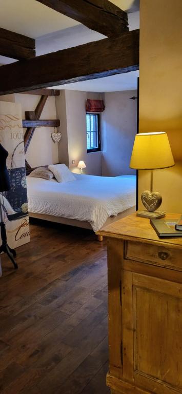 una camera da letto con un letto e un tavolo con una lampada di La Tour de la Chapelle - Parking privé a Obernai