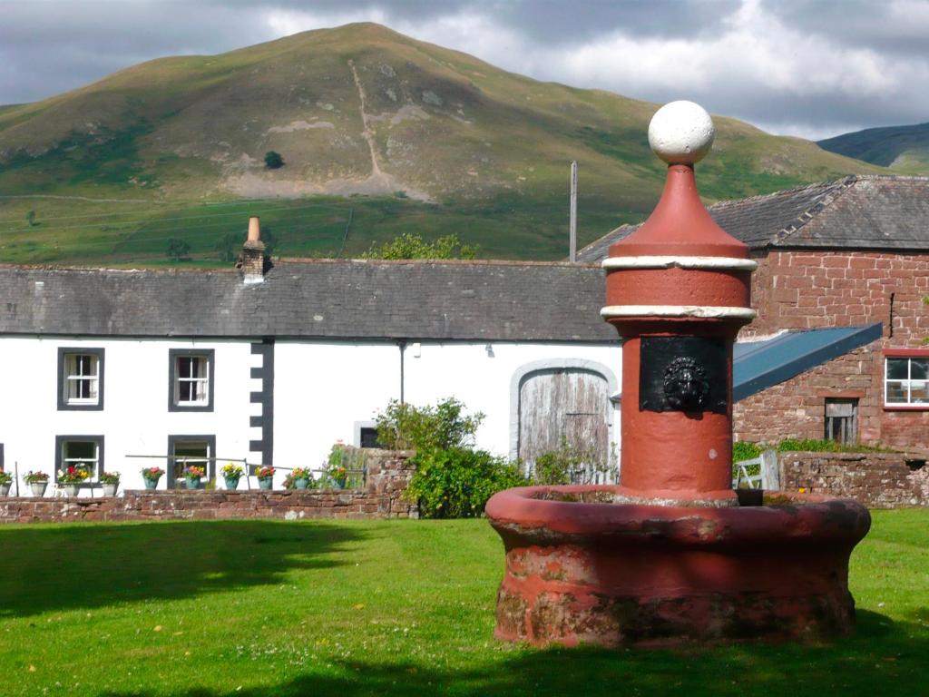 a red and black lighthouse in front of a house at YHA Dufton in Appleby