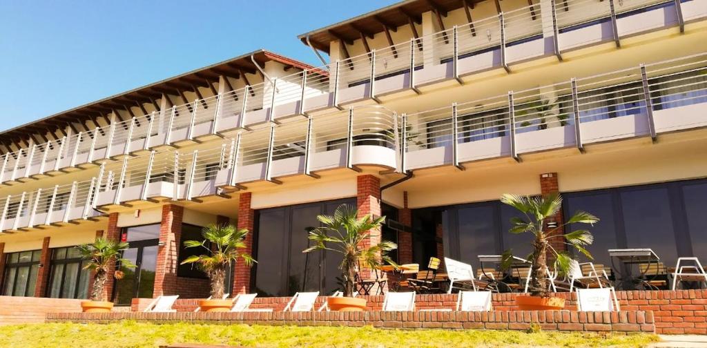 DługiePensjonat Długie Lubuskie的一座带桌椅的阳台的建筑