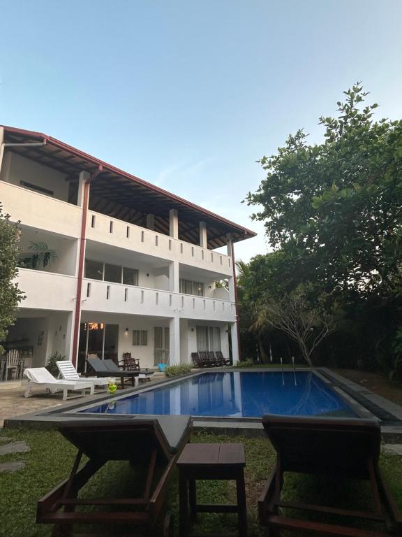 希克杜沃Jippie The Villa的一栋建筑前有游泳池的度假村