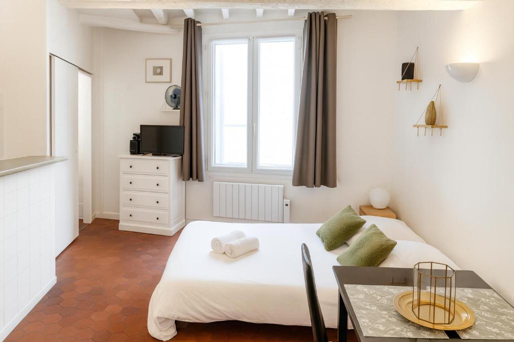 a small bedroom with a bed and a table at Le Papassaudi by La Familia in Aix-en-Provence