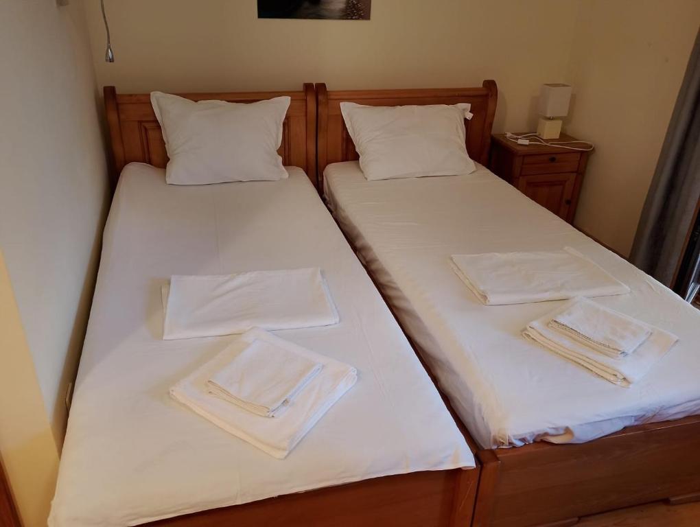 2 Einzelbetten mit weißen Handtüchern drauf in der Unterkunft Garden of Eden- Apartments Sweet Dreams Rey&Mar Saint Vlas in Sweti Wlas