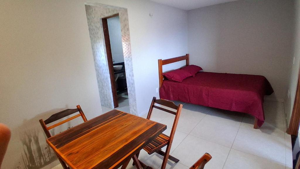 Un dormitorio con una cama y una mesa y una mesa y sillas. en Chalé Lá Aurora, en Guaramiranga