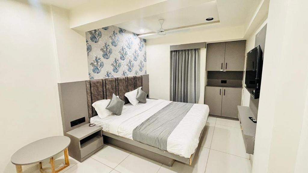 Un pequeño dormitorio con una cama y una cocina. en Hotel A One, en Jāmb