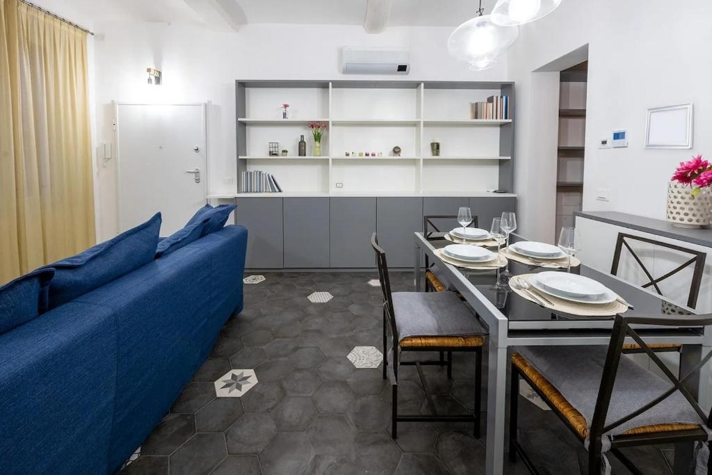 Emilia Suite Edition في مودينا: غرفة معيشة مع أريكة زرقاء وطاولة