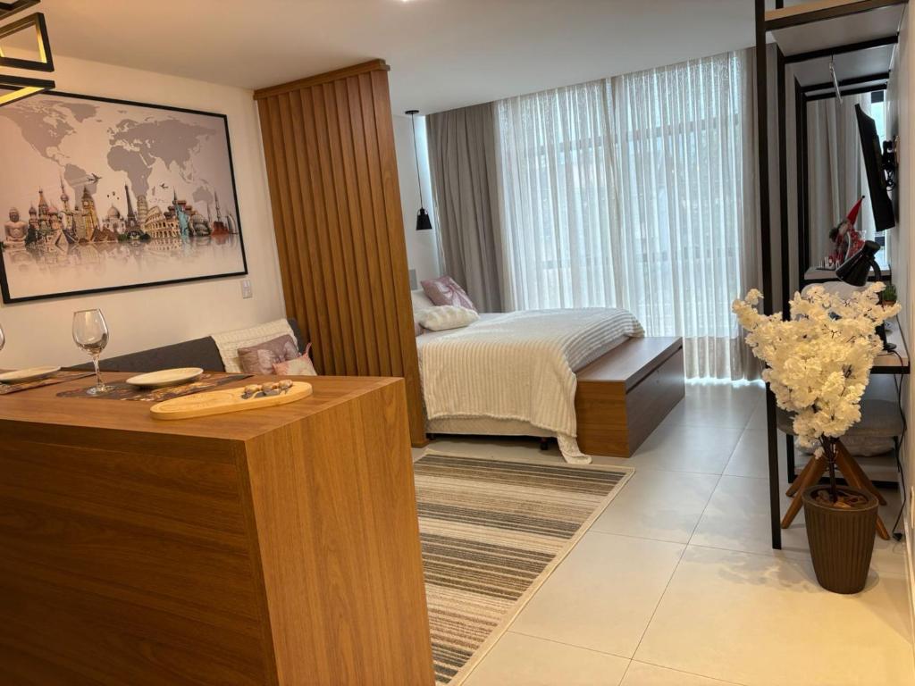 een slaapkamer met een bed en een tafel met een wijnglas bij Apartamento Milla 1 in Pomerode