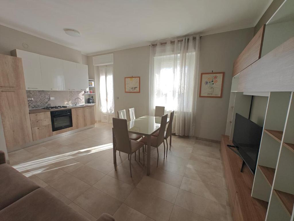 Una cocina y un comedor con mesa y sillas. en Mavin Apartments Cuneo, en Cuneo