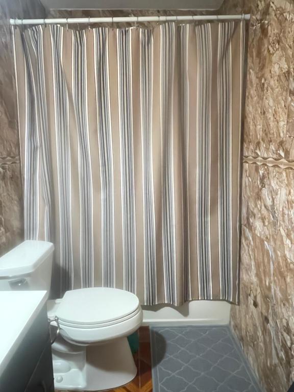 Un baño con inodoro y cortina de ducha en Cozy home, en Pompano Beach