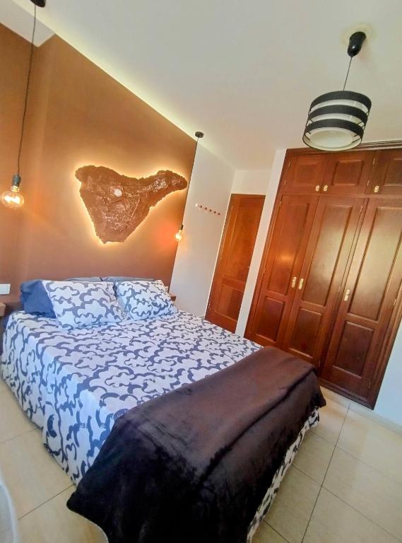 a bedroom with a bed and a wall at Surf Harbour Homestay in Los Abrigos
