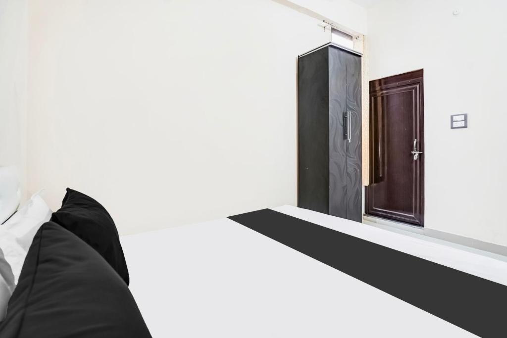 a bedroom with a black door and a bed at Spot on hotel meena in Jhūsi